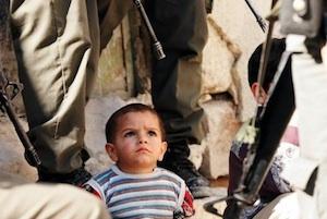 Picture: A Palestinian child surrounded by Israeli soldiers courtesy occupiedpalestine.wordpress.com.