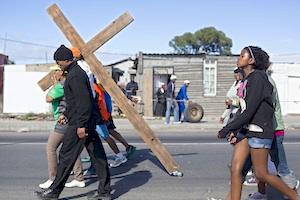Picture: Heavy cross to bear - community members from the township of Gugulethu hold a march to raise awareness of the "hellish reality" of township life (courtesy Abahlali baseMjondolo/flickr).