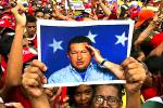 Picture: A picture of the immensely popular late Venezuelan president, Hugo Chavez, held aloft by his supporters, courtesy The Times.